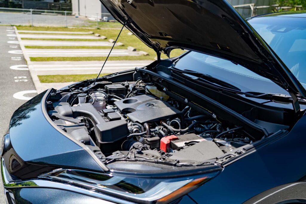 	駐車場でボンネットを開けた車のエンジンルーム