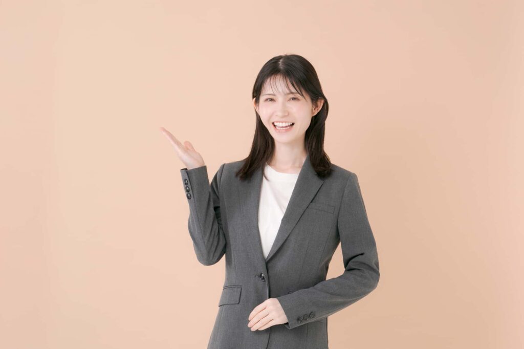ナチュラルな背景の前で説明するスーツ姿の女性