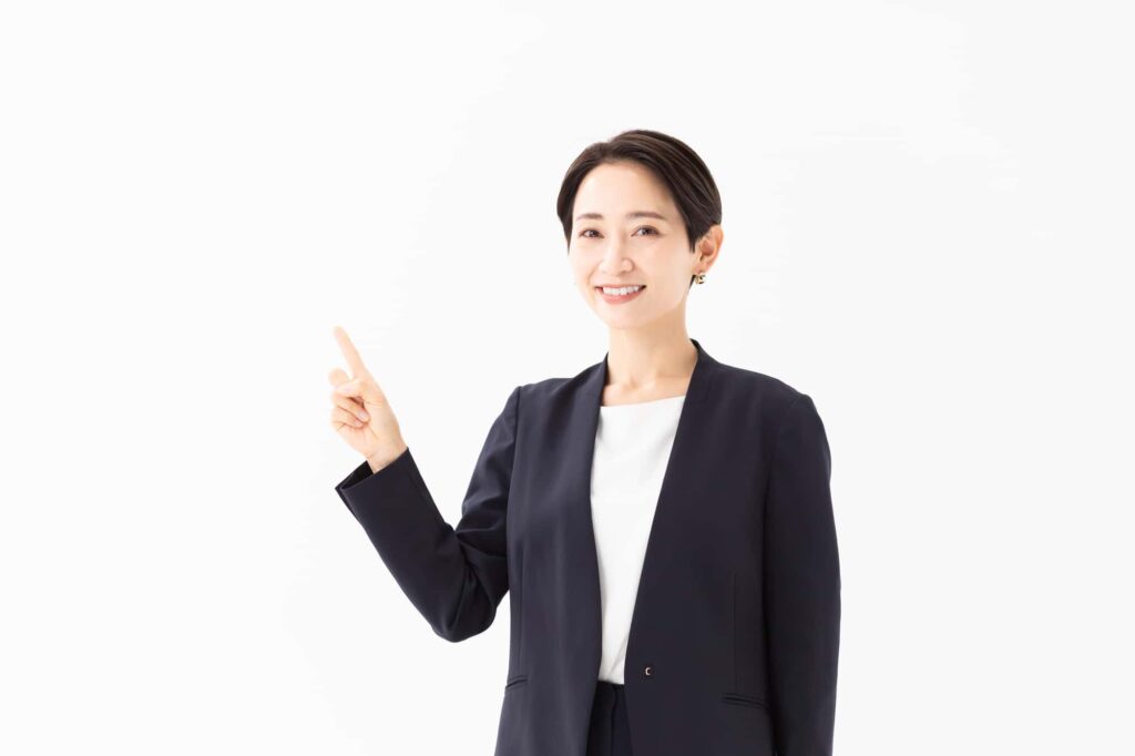 人差し指を立てて説明するスーツ姿の女性