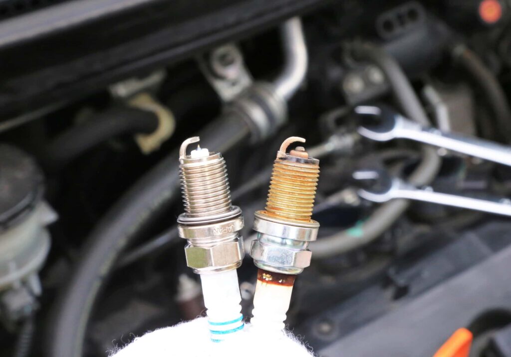 新品と使用済みのスパークプラグの比較とエンジンルーム
