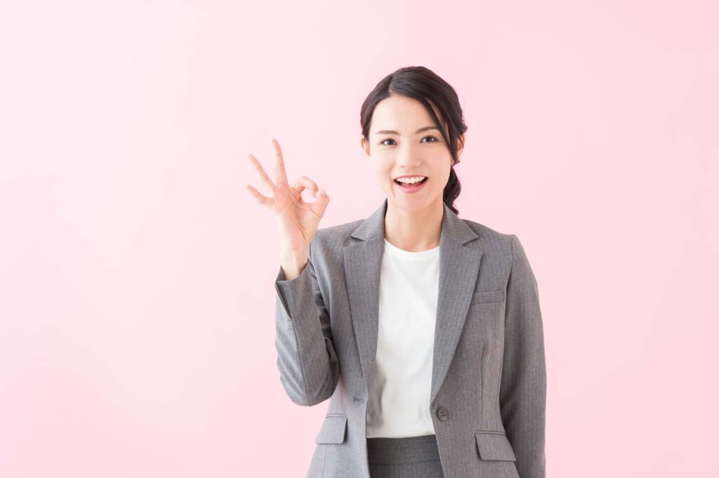 手でOKマークを作る女性