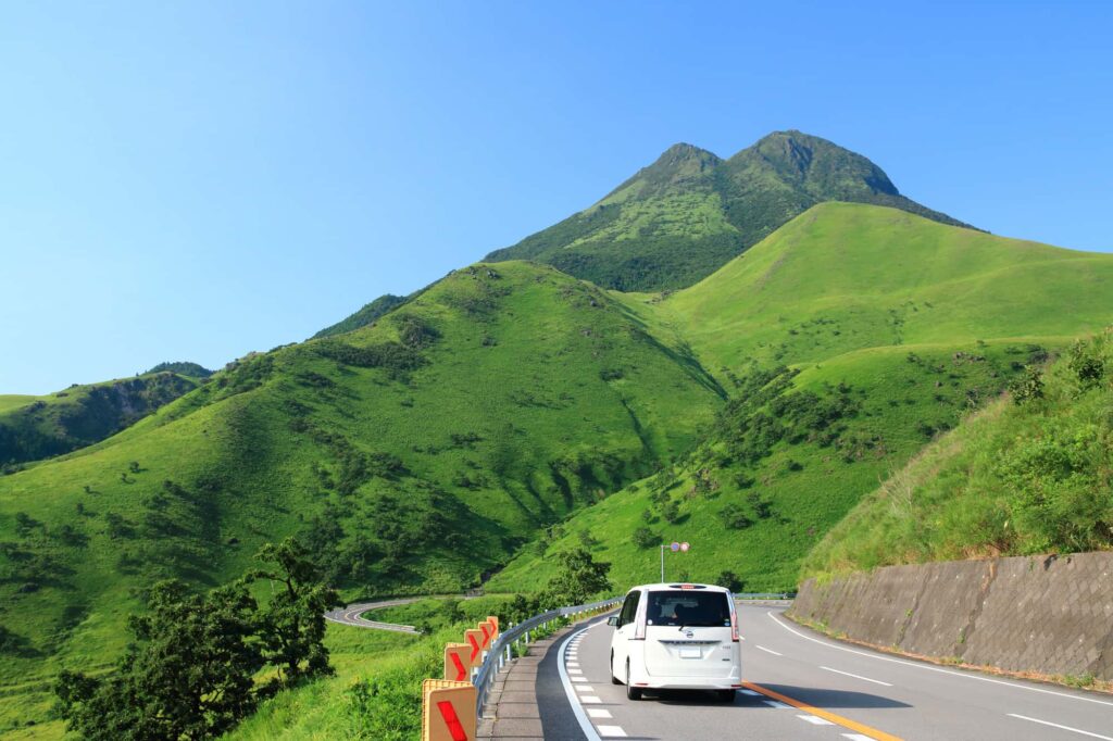 山を背景に道路を走る車