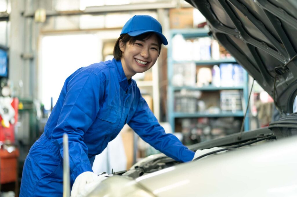 車の整備をする青い服を着た女性