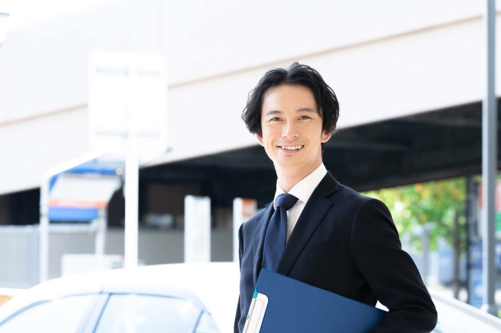 車の前でほほ笑む男性