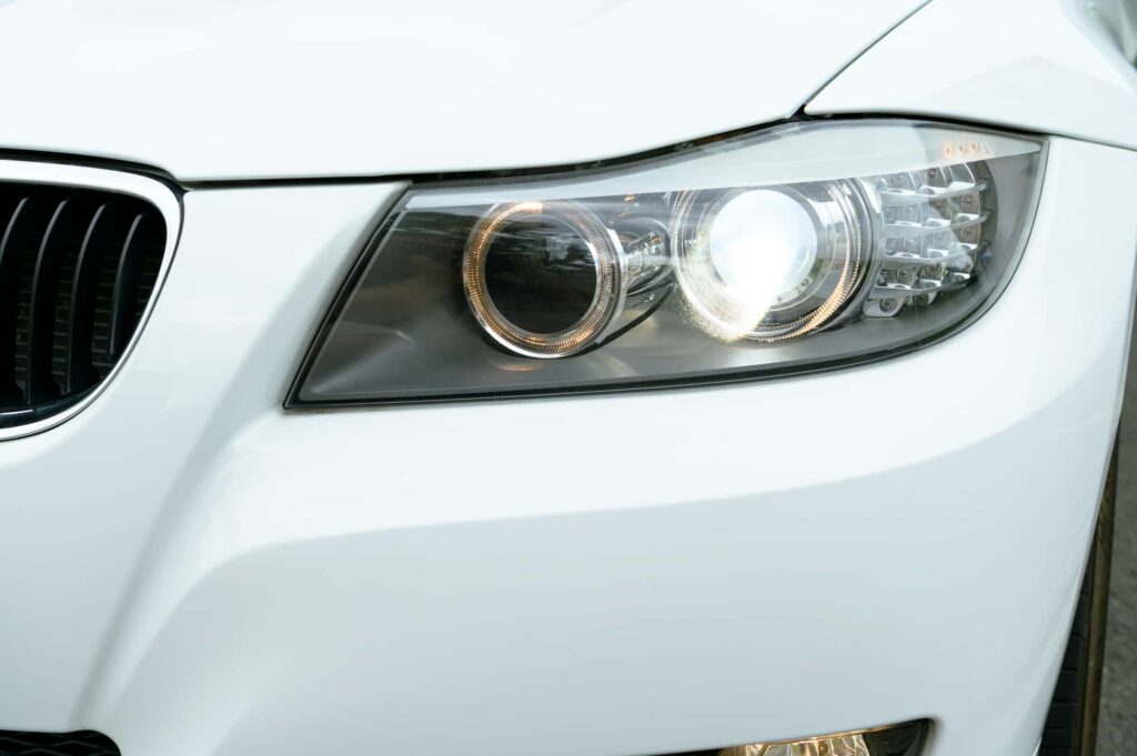 白の車の点灯しているヘッドライト