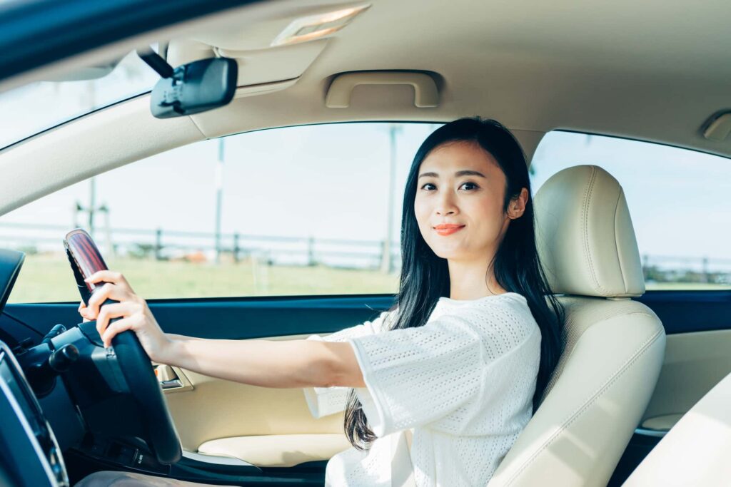 ハンドルを握ってこちらを見つめる女性