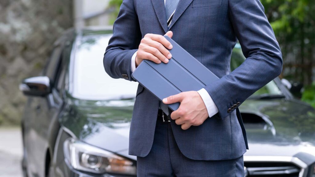 車の前に立つビジネスマン