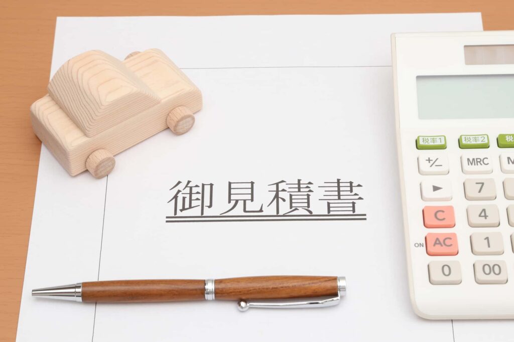 木のミニカーと電卓とペン