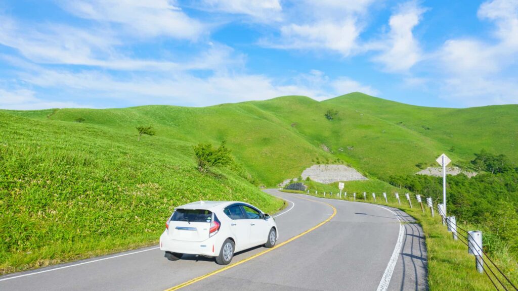 青空の山の中を走る車