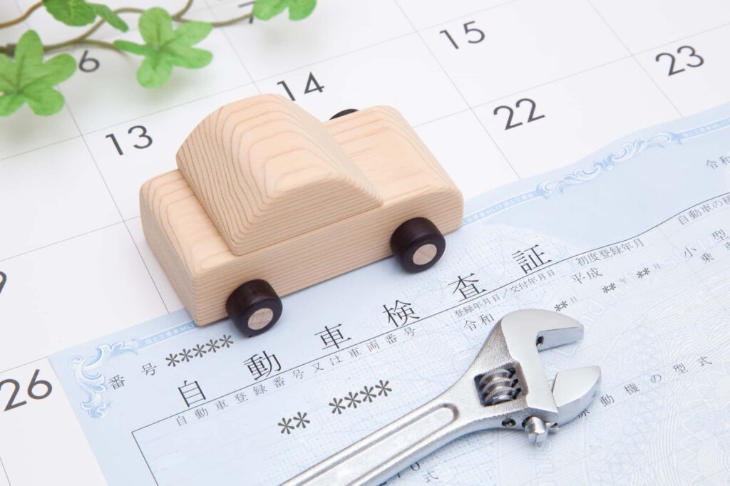 自動車検査証と木のミニカー