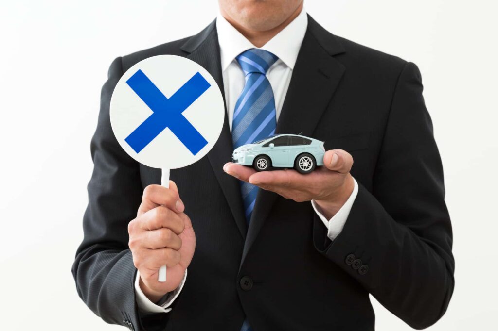 車に×マークを出すスーツ男性