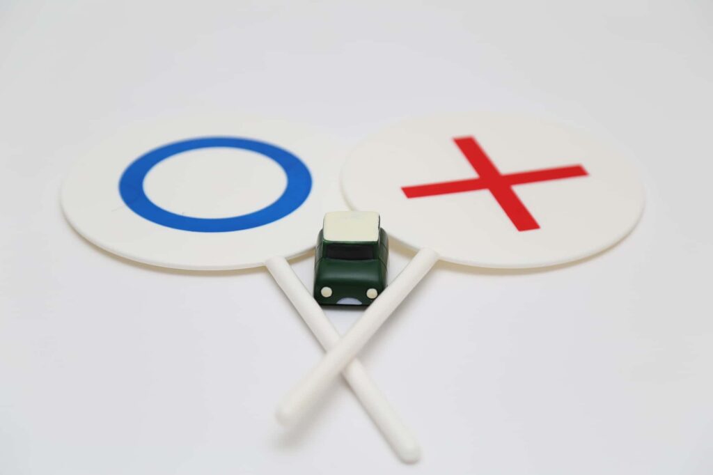 〇と×の札の間にある緑のミニカー