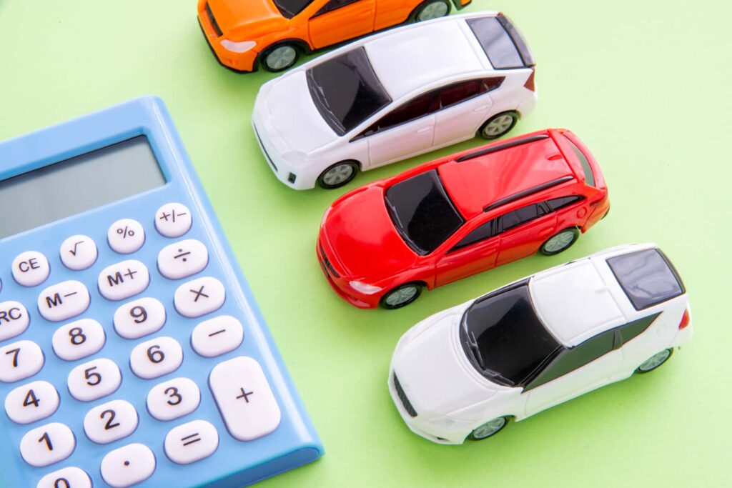 ミニカーと電卓、車の費用計算