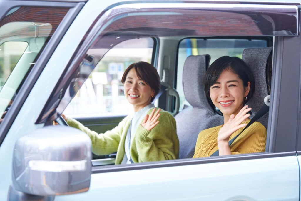 車に乗って手を振る女性たち