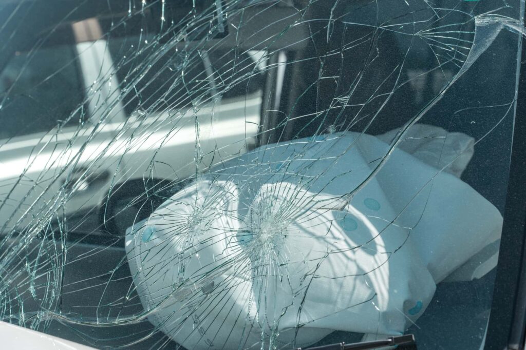 割れた車のフロントガラスとエアバッグ