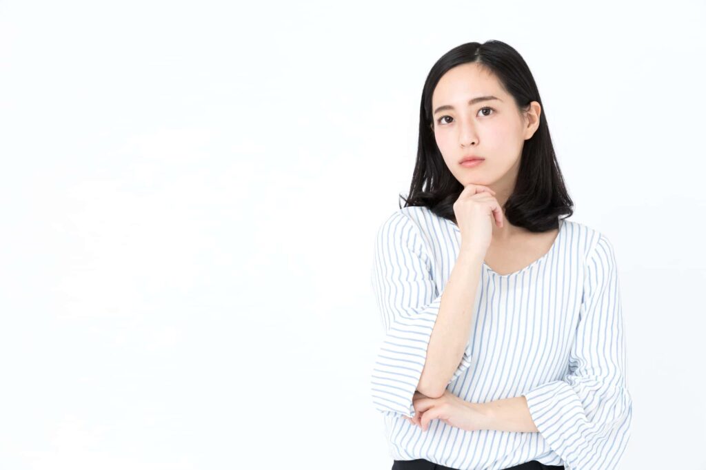 腕を組み考える女性