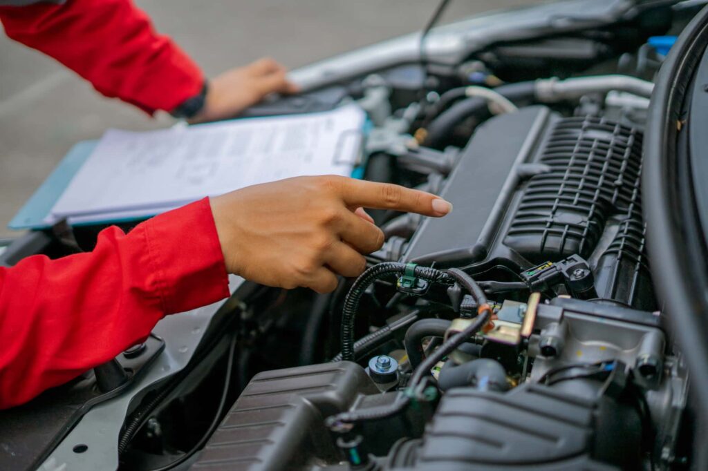 整備士が車のエンジンルームを点検