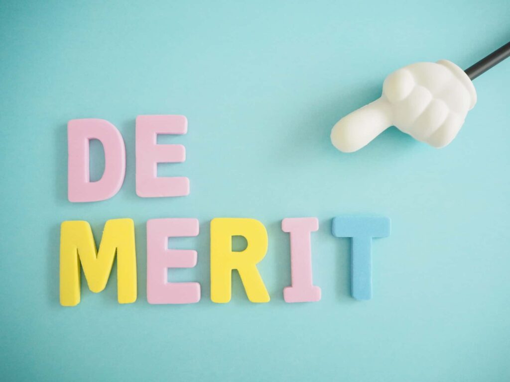 デメリット（DEMERIT）と書かれたカラフルな文字