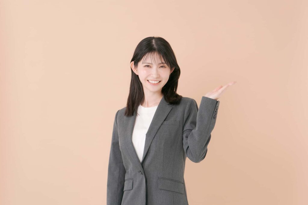 笑顔で手のひらをこちらに向けているビジネスウーマン