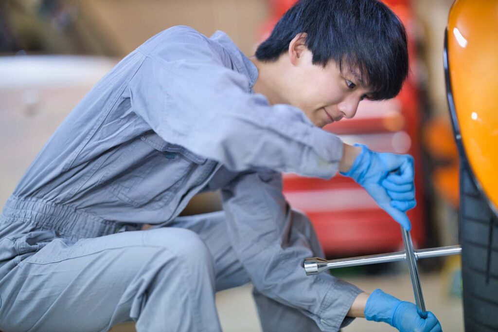車のタイヤを整備する男性