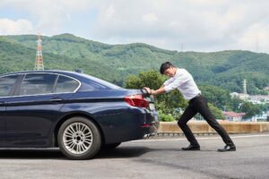 故障した車を押す男性