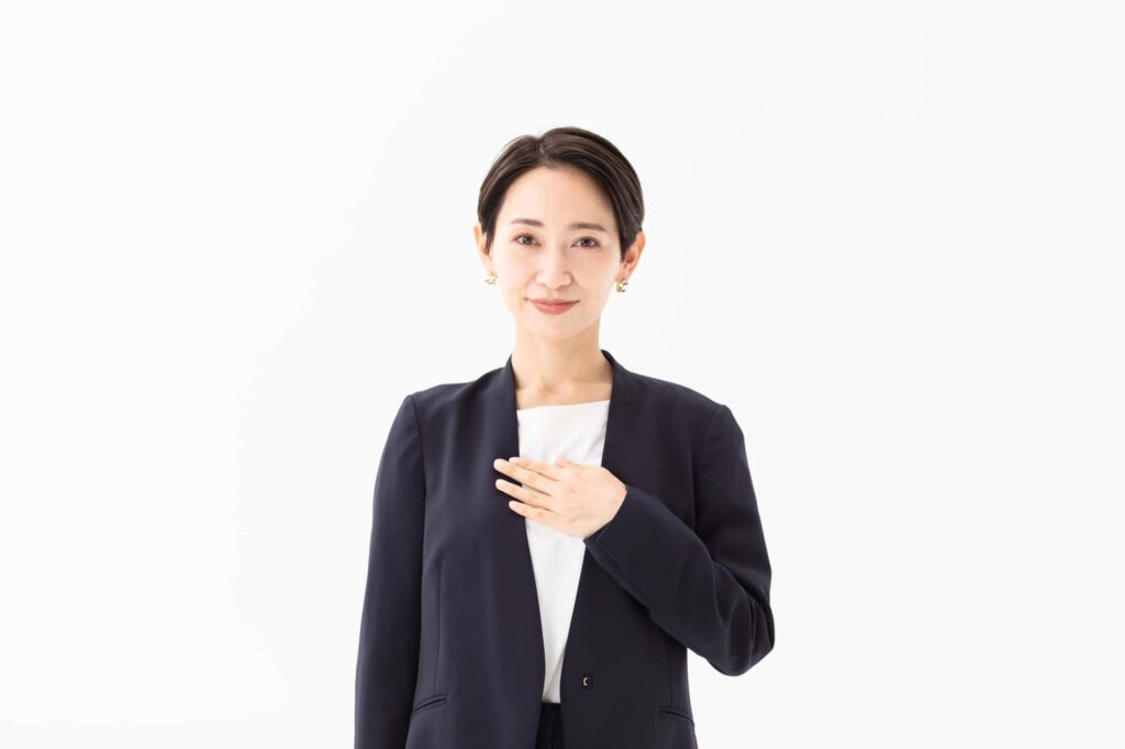 胸に手を当てるビジネスウーマン