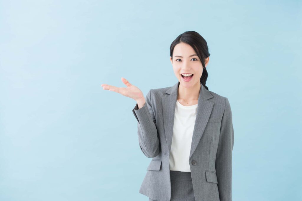 手のひらを見せて案内するビジネスウーマン