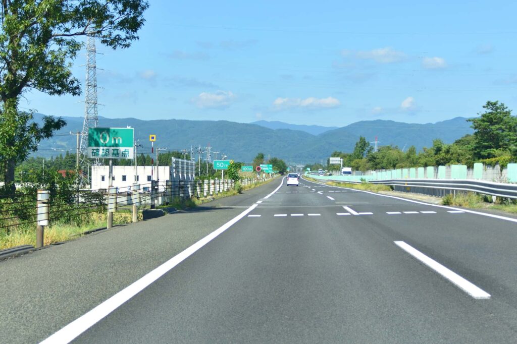 高速道路を走る車と遠くの山々