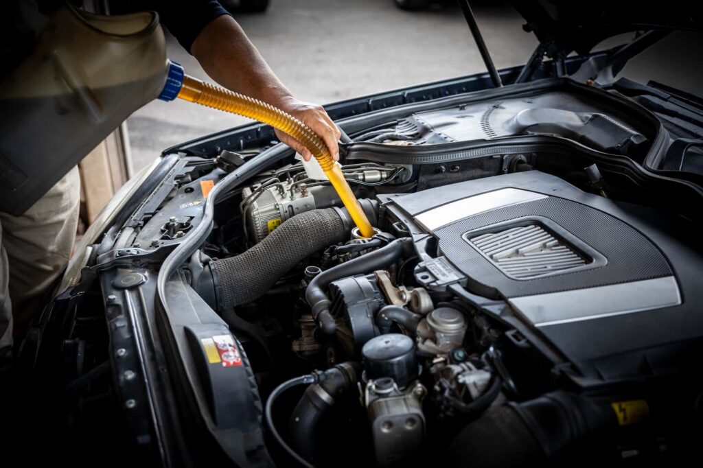 MINIのエンジンにエンジンオイルを注ぎ込む様子