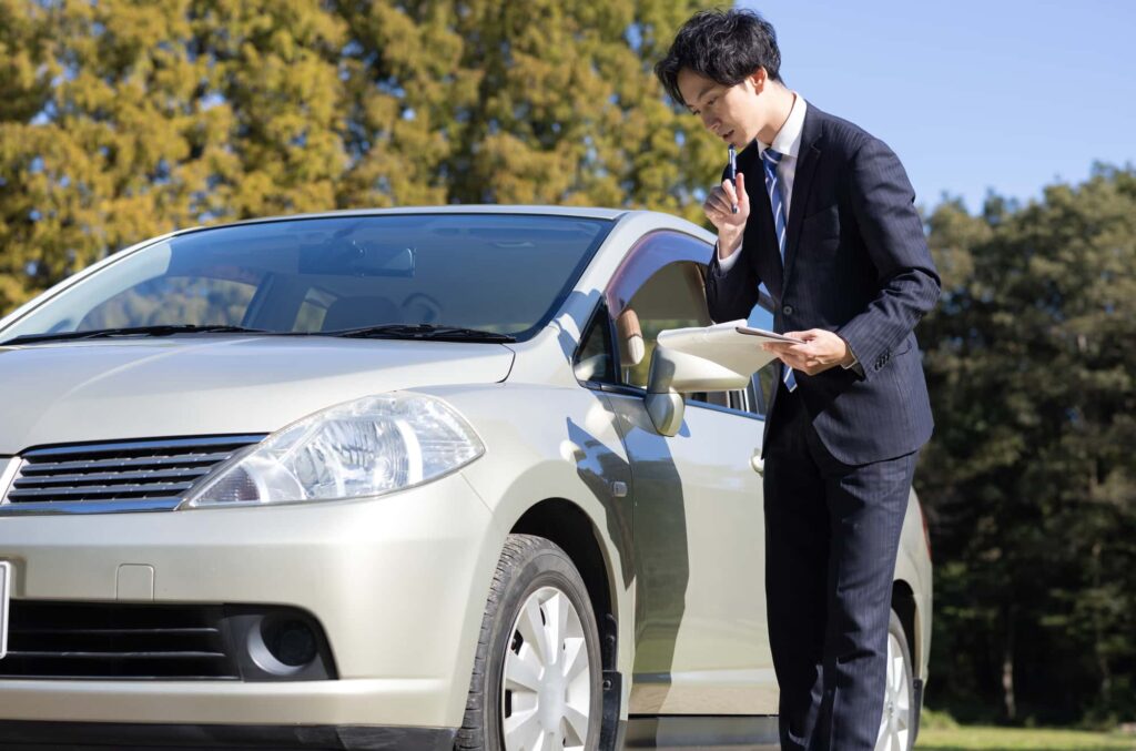 車を点検するビジネスマン