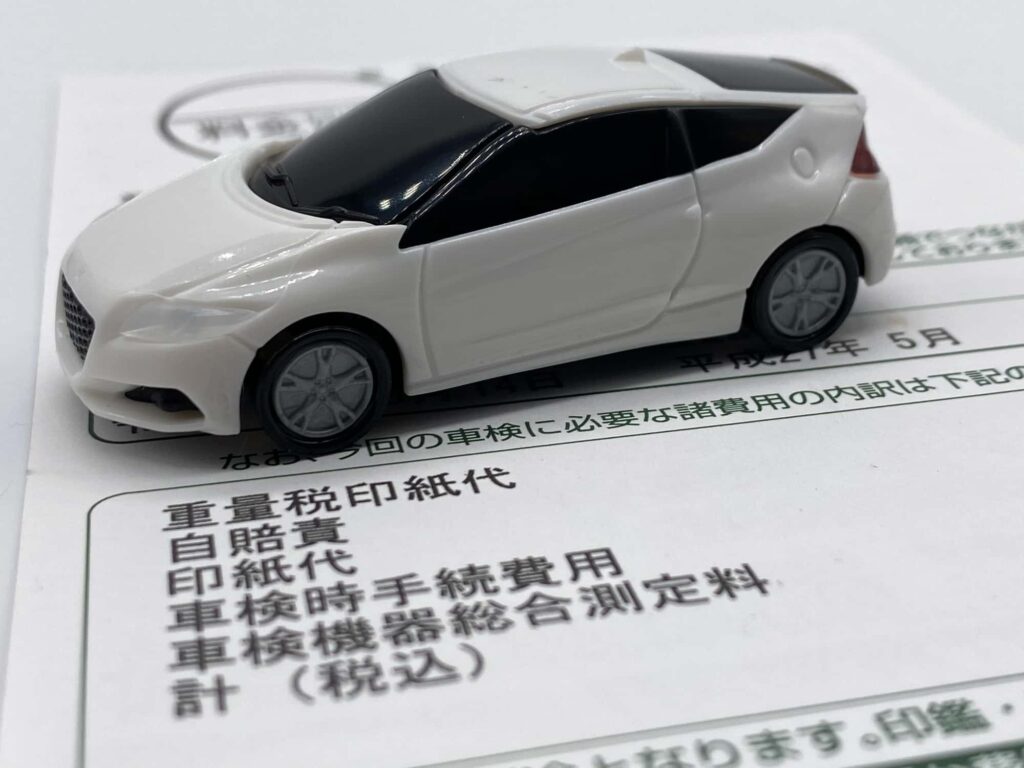 車検費用が記載された書類とミニカー