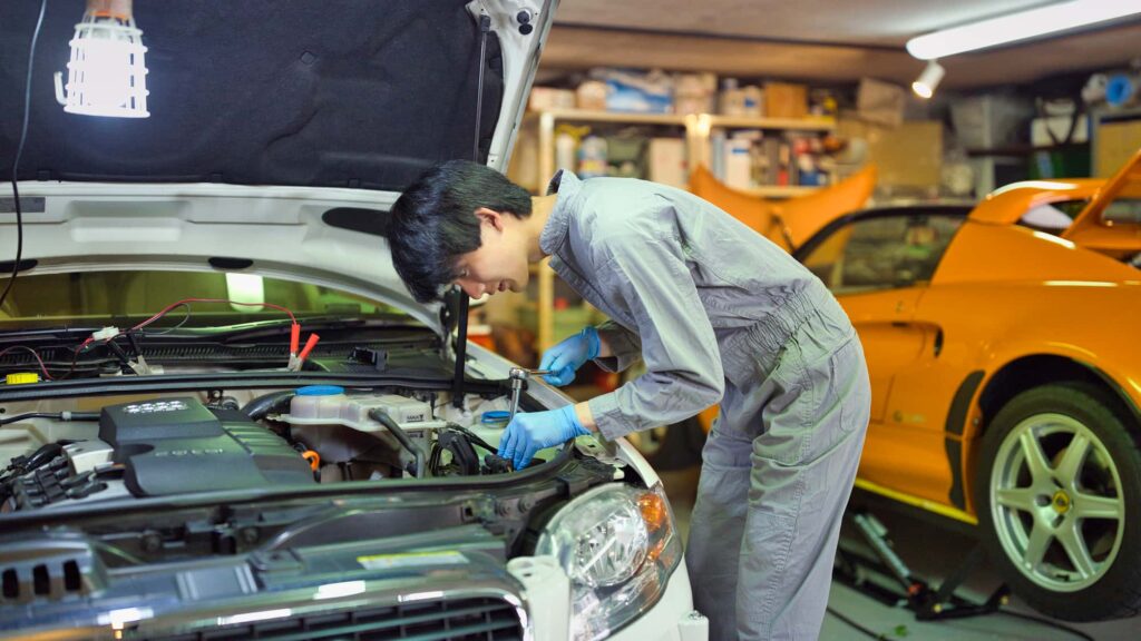 ガレージで車を整備する男性